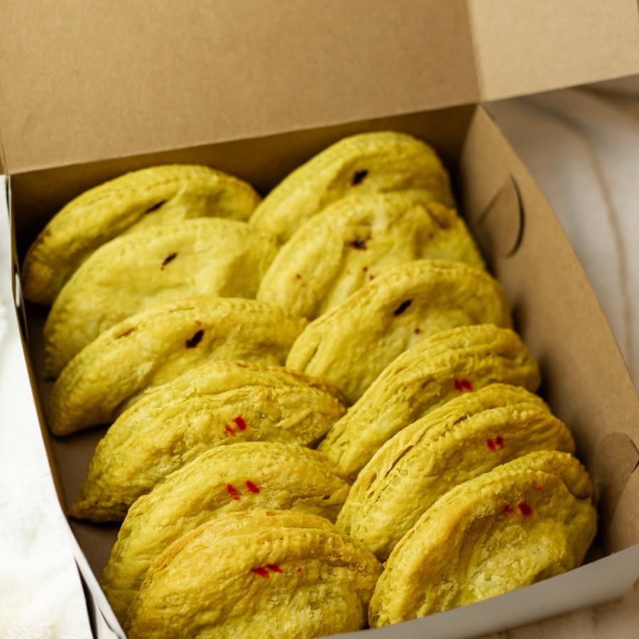An open box packed with a dozen golden patties