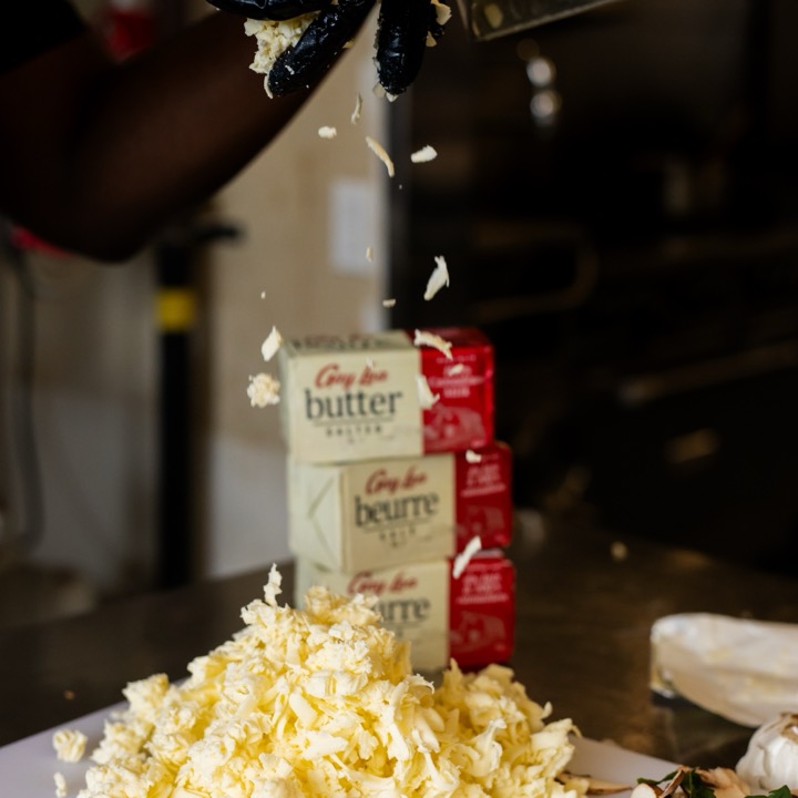 Cold butter being grated by hand into a pile for the pastry